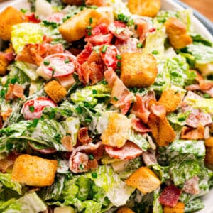 square close up image of BLT salad tossed in dressing