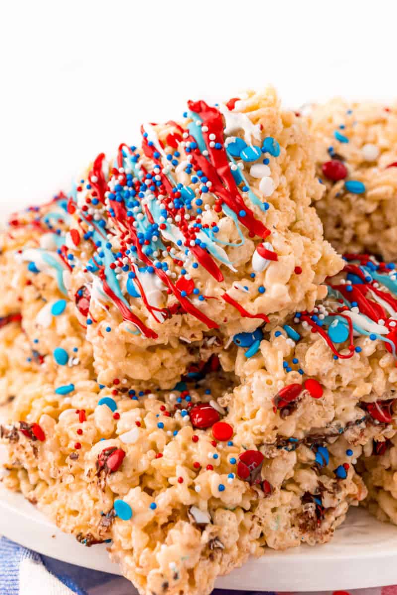side view of a plate of 4th of july rice krispie treats with red, white, and blue candy melts and sprinkles on top