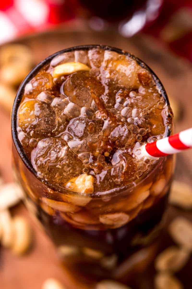 looking into a glass with peanuts and coke with bourbon and ice