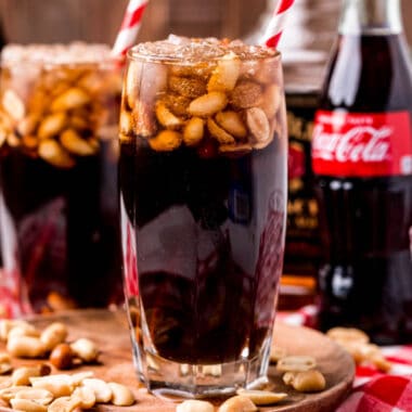 square image of peanuts and coke in glasses with straws