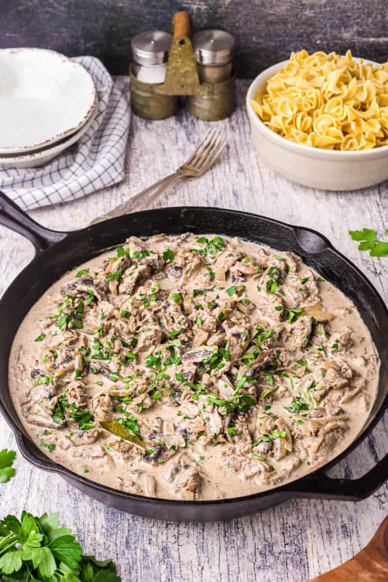 beef stroganoff sauce topped with chopped parsley in a skillet