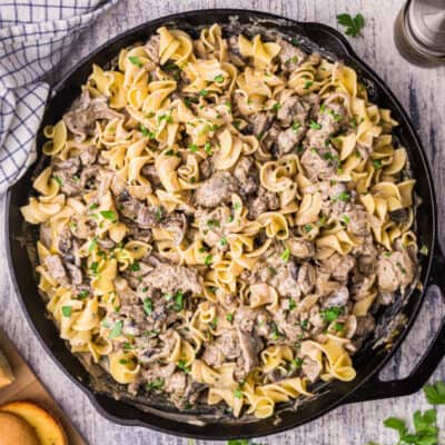 square image of beef stroganoff with egg noodles in a cast iron skillet
