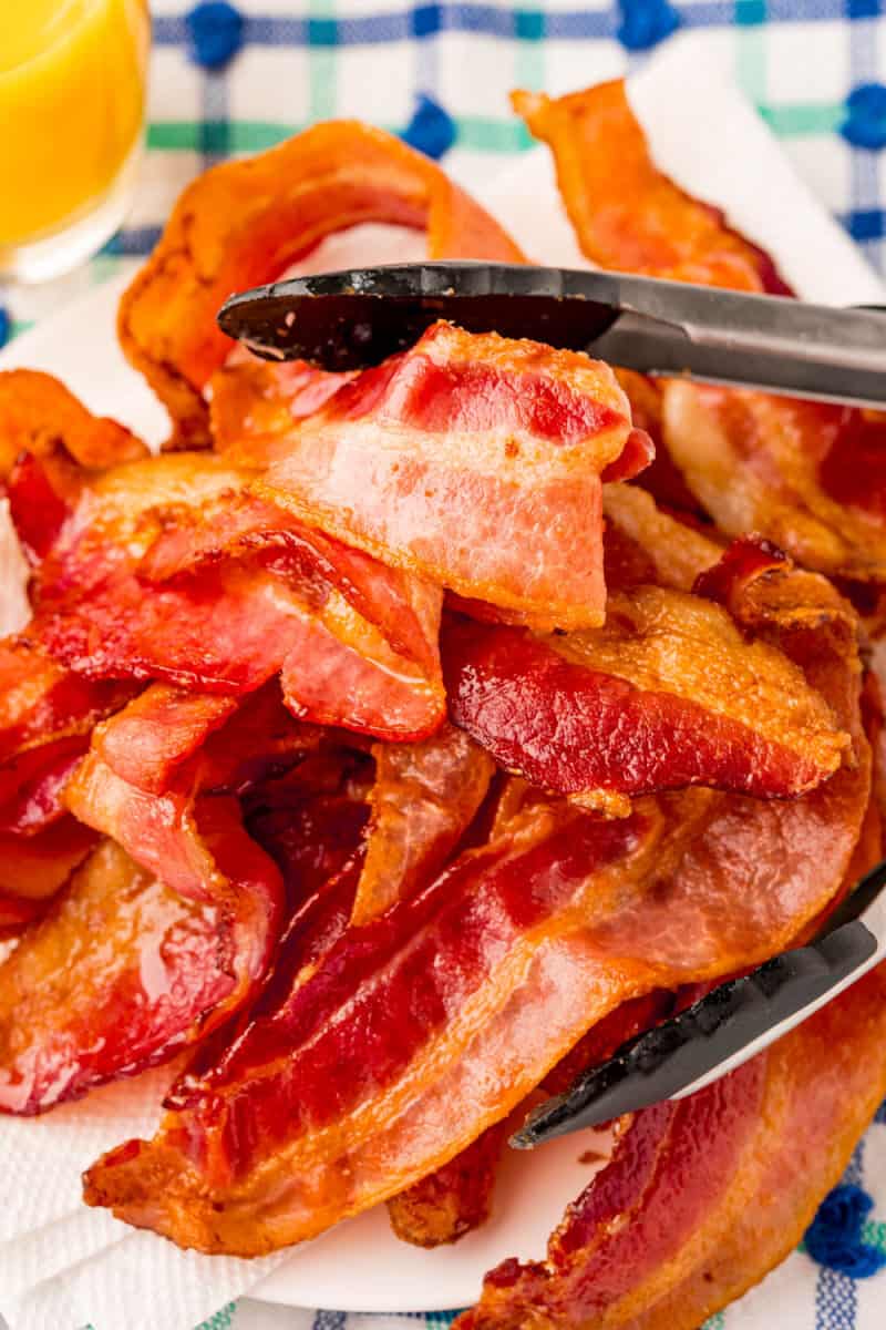 plate of air fryer bacon with tongs for serving