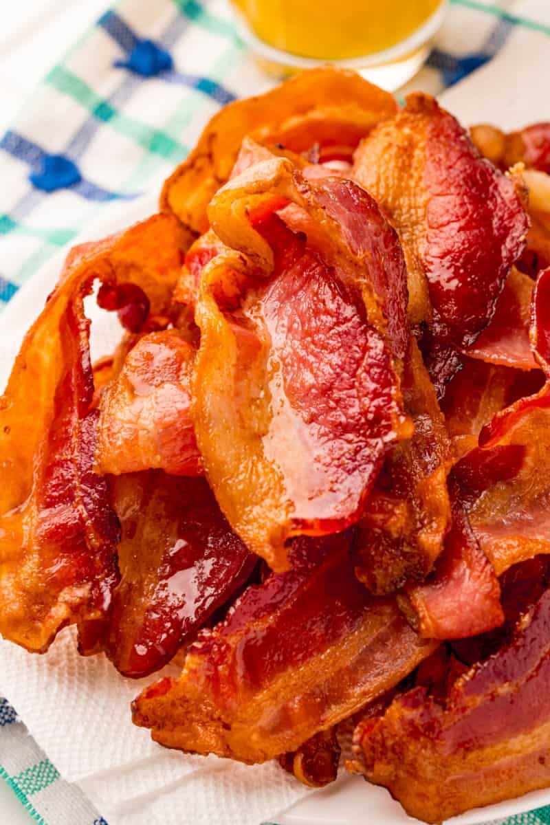 pile of air fryer bacon on a paper towel-lined plate
