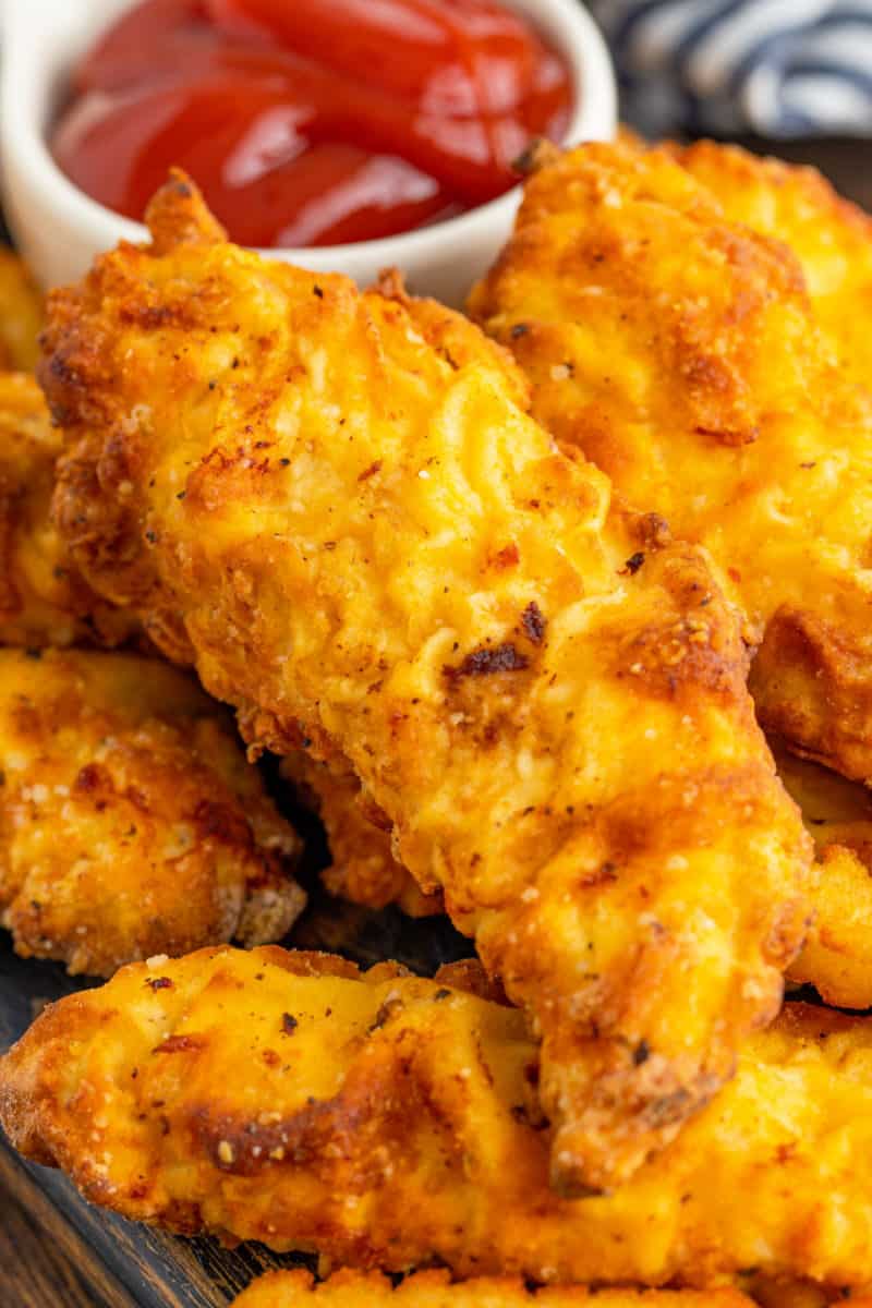 close up of golden brown chicken tenders piled up
