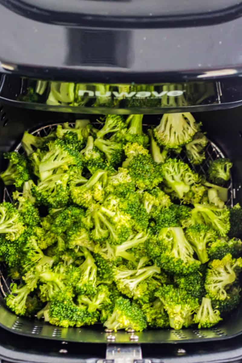 broccoli florets in an air fryer basket before cooking