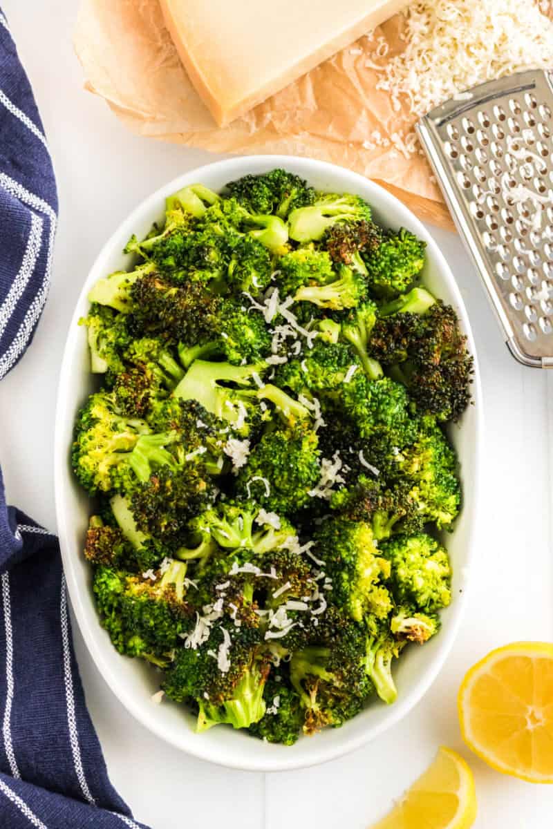 air fryer broccoli in a serving bowl with lemon and parmesan