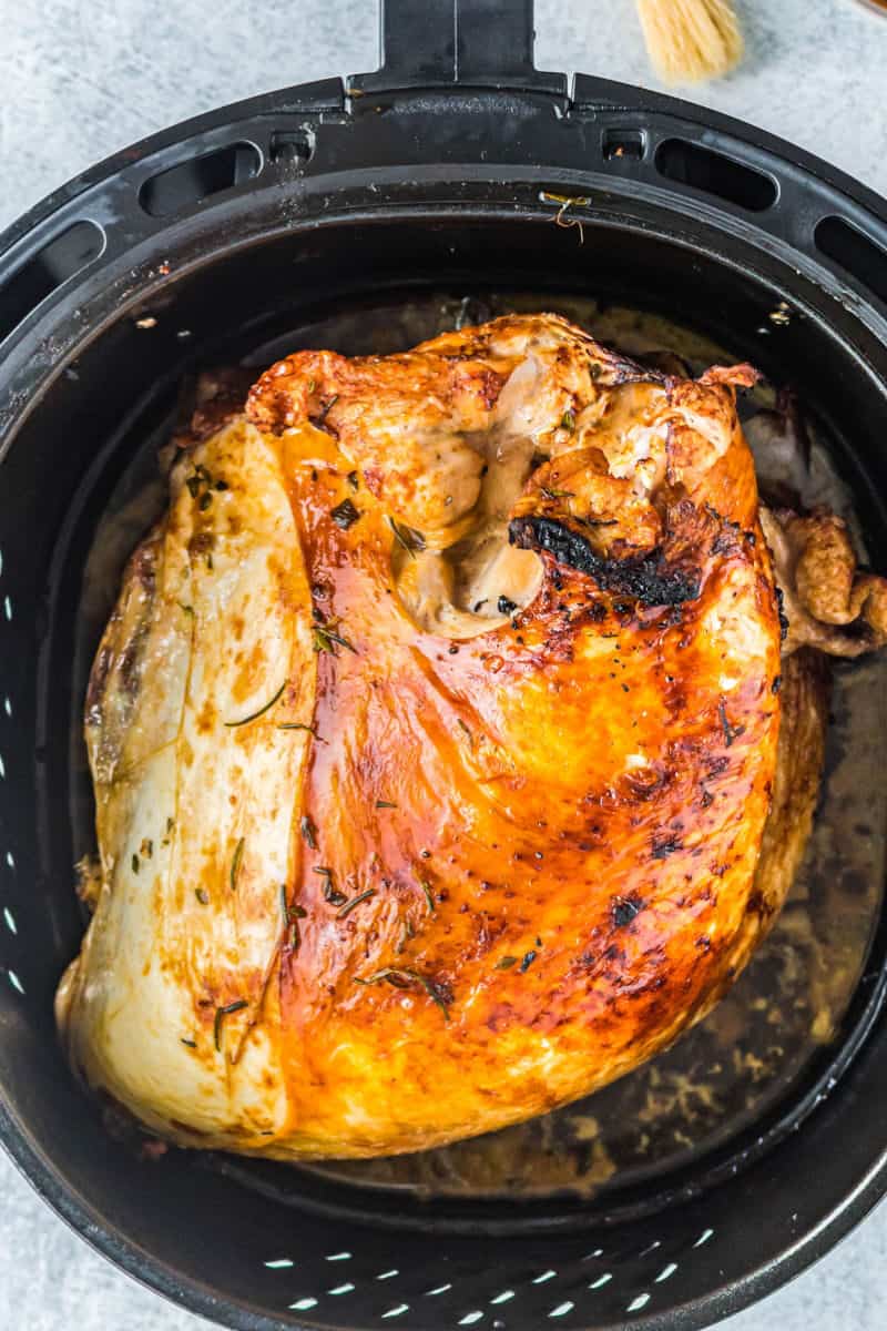 roasted turkey in an air fryer basket before glazing