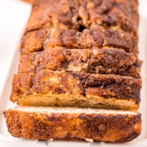 square image of a loaf of cinnamon swirl quick bread cut into slices