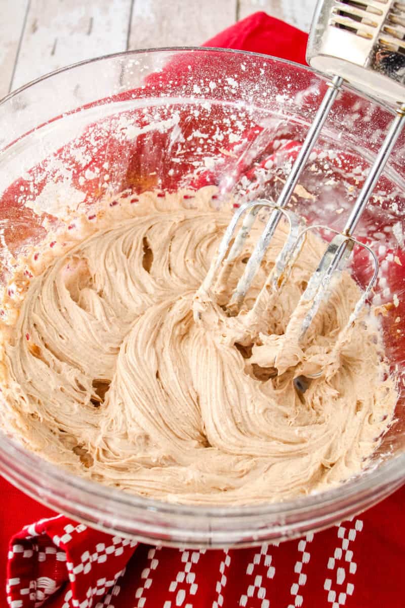 cinnamon butter cream in a bowl with a hand mixer