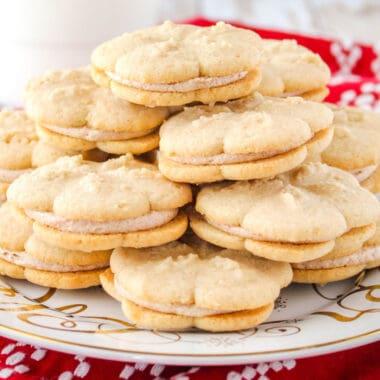 square image of cinnamon spritz sandwich cookies piled up on a plate