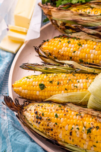 grilled corn on the cob next to a stick of butter