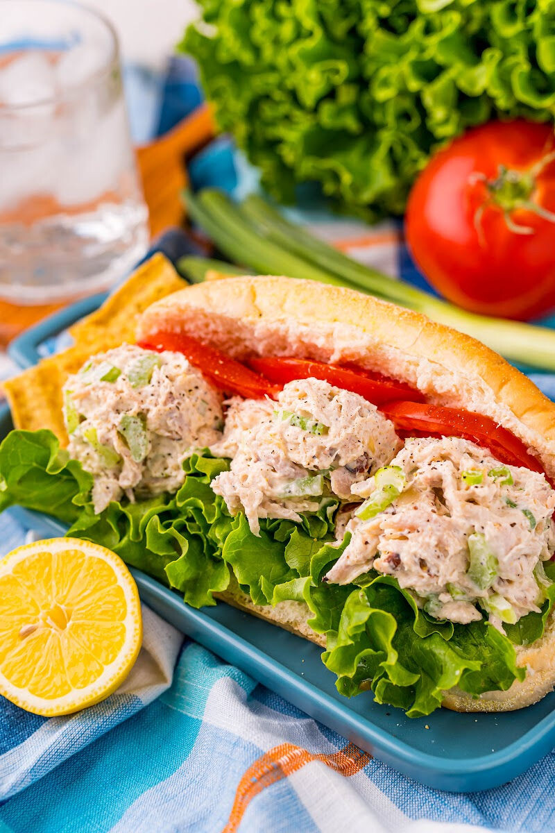 chicken salad sandwich on a hoagie roll with lettuce and tomato slices