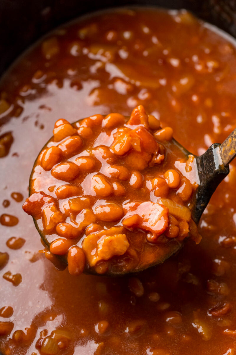 ladle of crockpot baked beans over the slow cooker