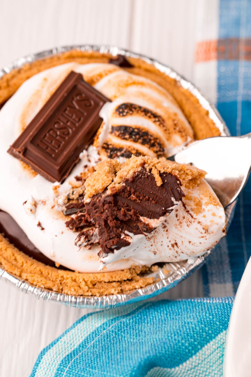 bite of mini s'mores pie on a fork over the pie