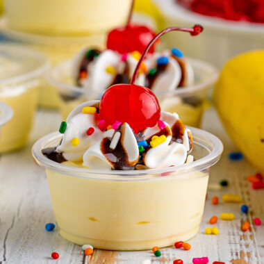 square image of banana split pudding shots with cool whip, chocolate syrup, sprinkles, and a cherry
