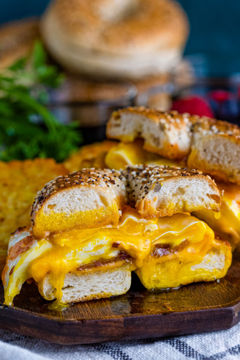 bacon, egg & cheese bagel breakfast sandwich cut in half to show runny egg yolk