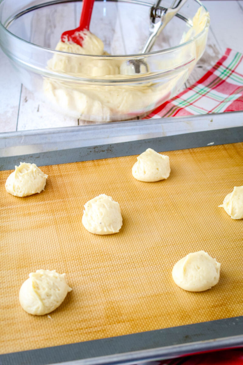 eggnog cake batter scoops on a silicone mat lined baking sheet
