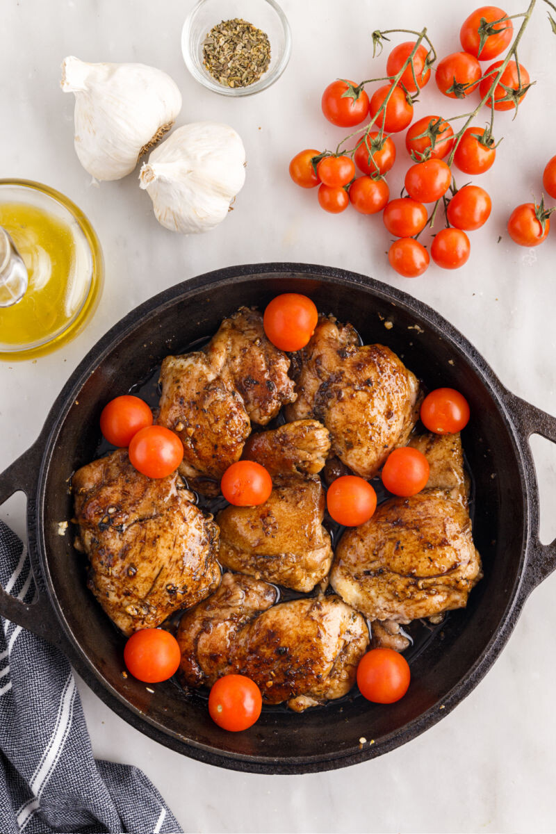 chicken thighs coated in garlic balsamic glaze with cherry tomatoes around them