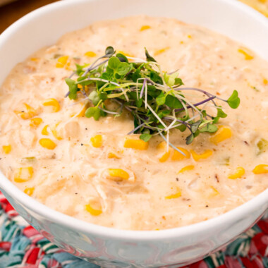 square image of chicken corn chowder in a bowl topped with micro greens