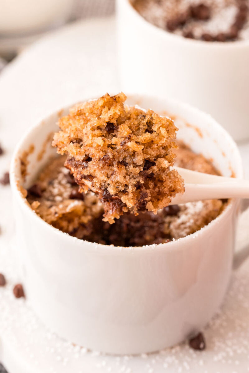 spoonful of chocolate chip cookie mug cake over the mug