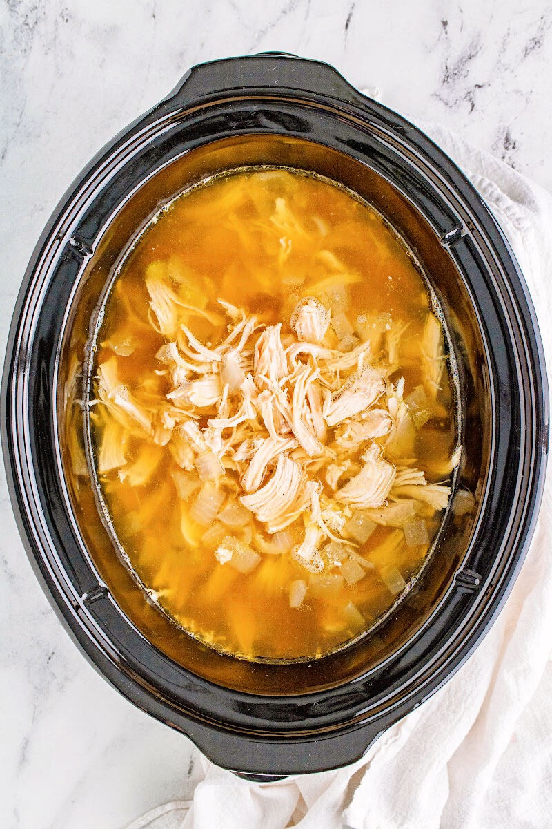shredded chicken in a crock opt with broth and veggies