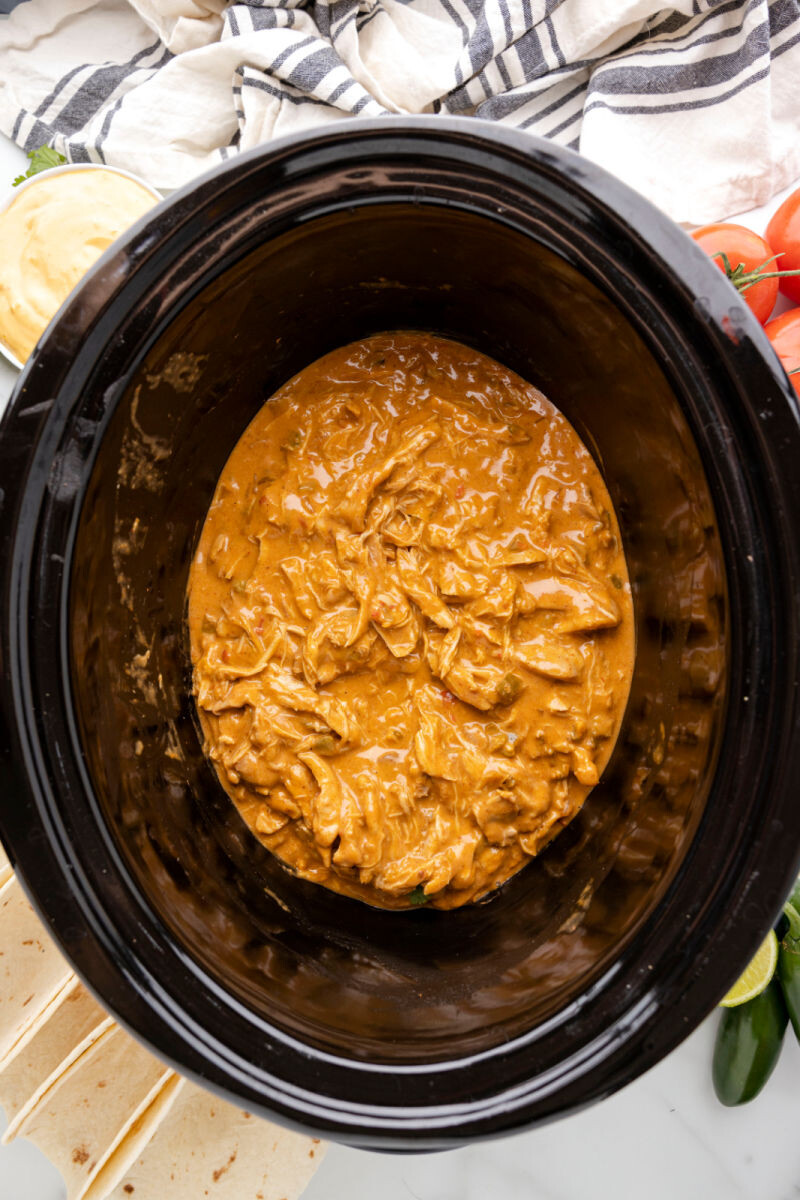 crock pot queso chicken in a slow cooker ready to be served