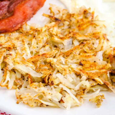 square image of hash browns on a plate with bacon