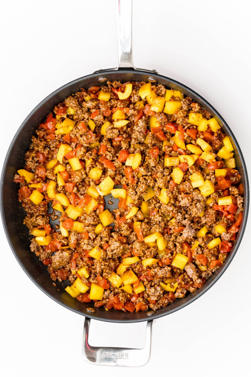 rotel tomatoes, yellow bell pepper, taco seasoning, and ground beef in a skillet