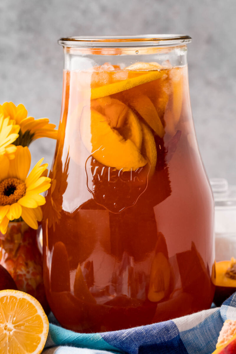 pitcher of peach sweet tea with peach and lemon slices