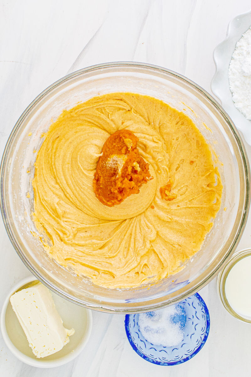 pumpkin puree added to cake batter in a mixing bowl