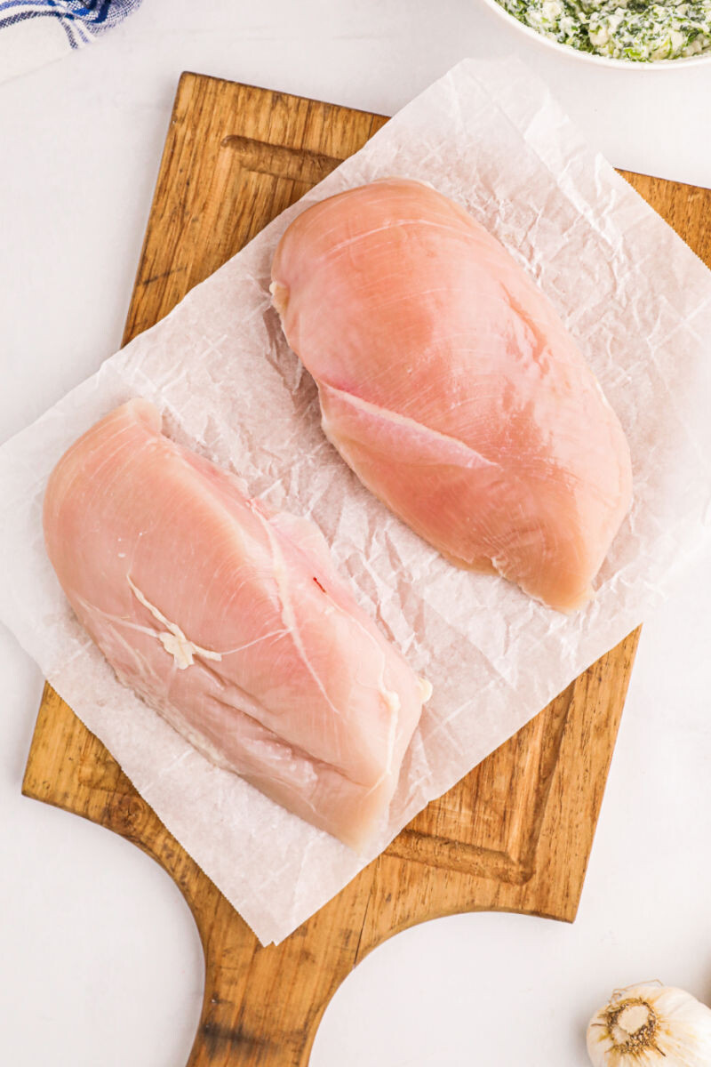 chicken breasts on a cutting board with a pocket cut into the side