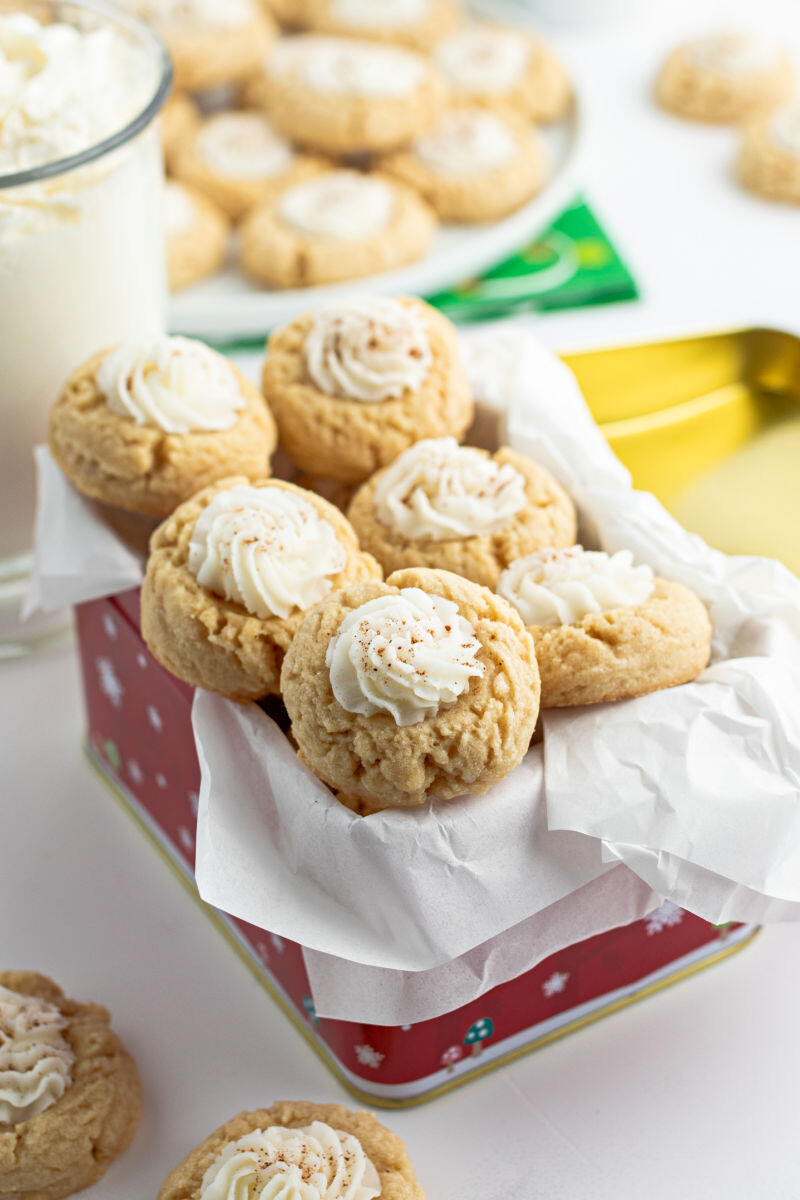 Christmas tin with parchment paper filled with eggnog thumbprint cookies