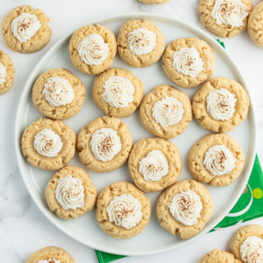 square image of eggnog thumbprint cookies on a plate