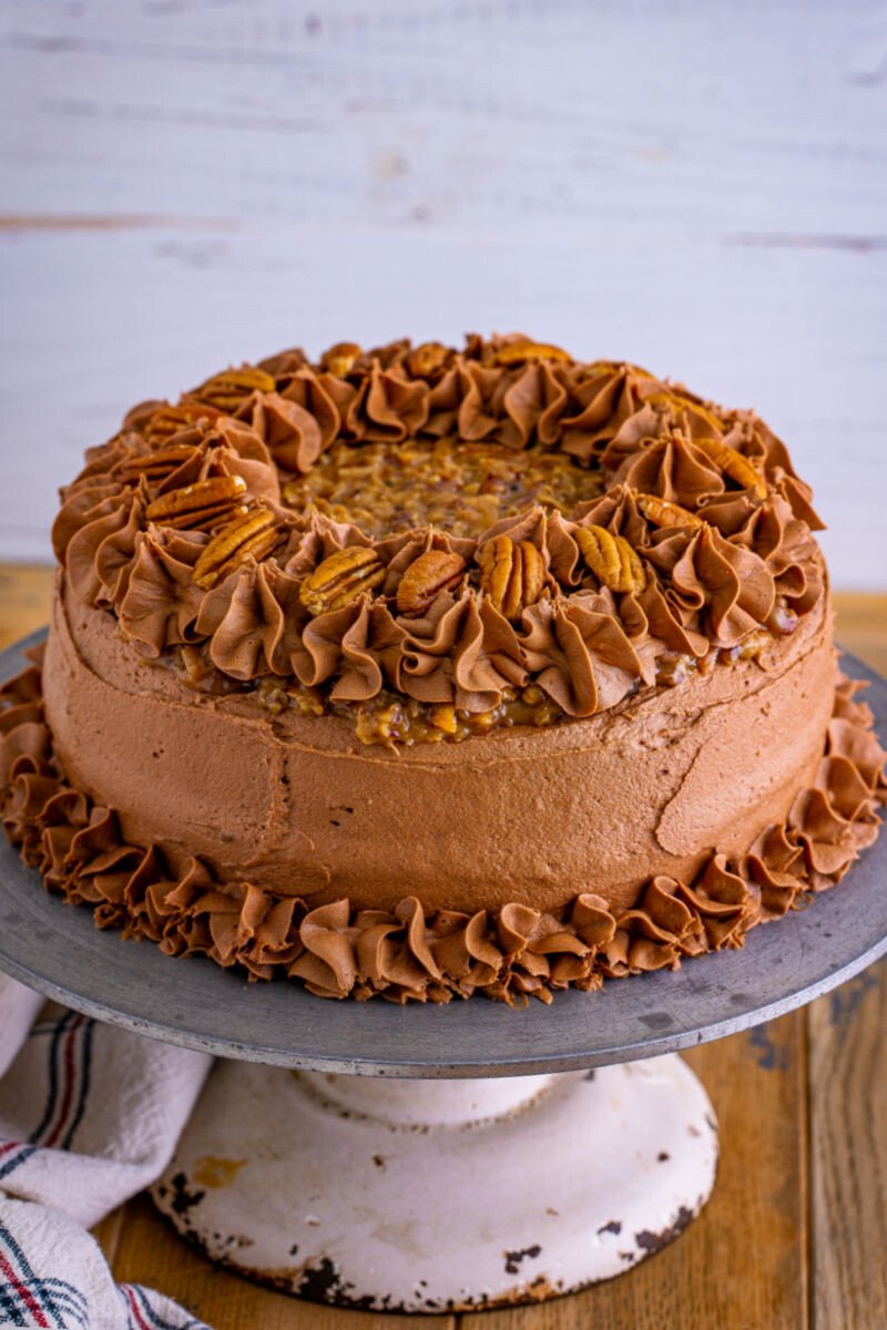 german chocolate cake with pecan coconut frosting and chocolate buttercream on a cake stand