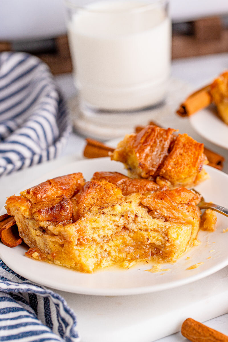 slice of honey bun bread pudding with a bite taken out to show the layers