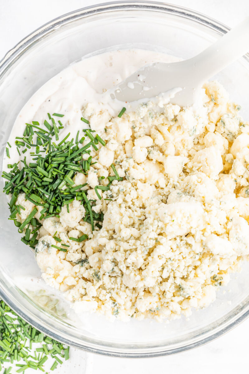 cream cheese mixture in a bowl with blue cheese crumbles and chopped chives