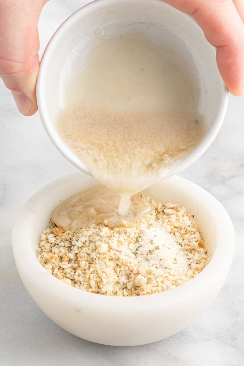metled butter being poued over italian seasoned panko and garlic salt in a bowl
