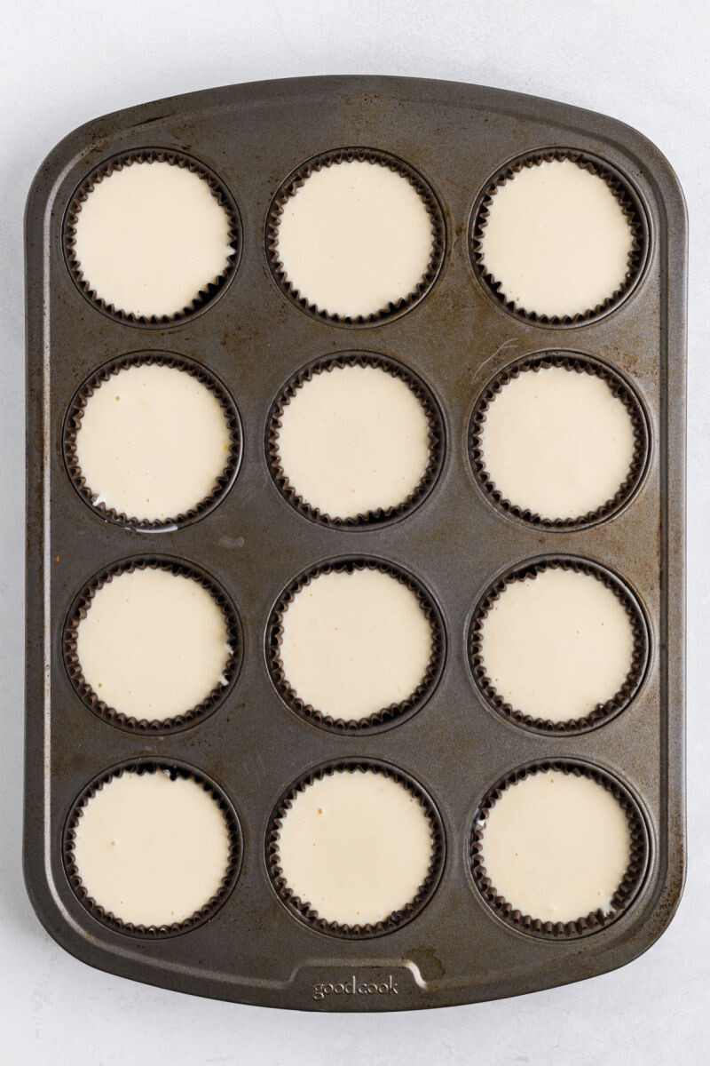 muffin tin cups filled with baileys cheesecake batter