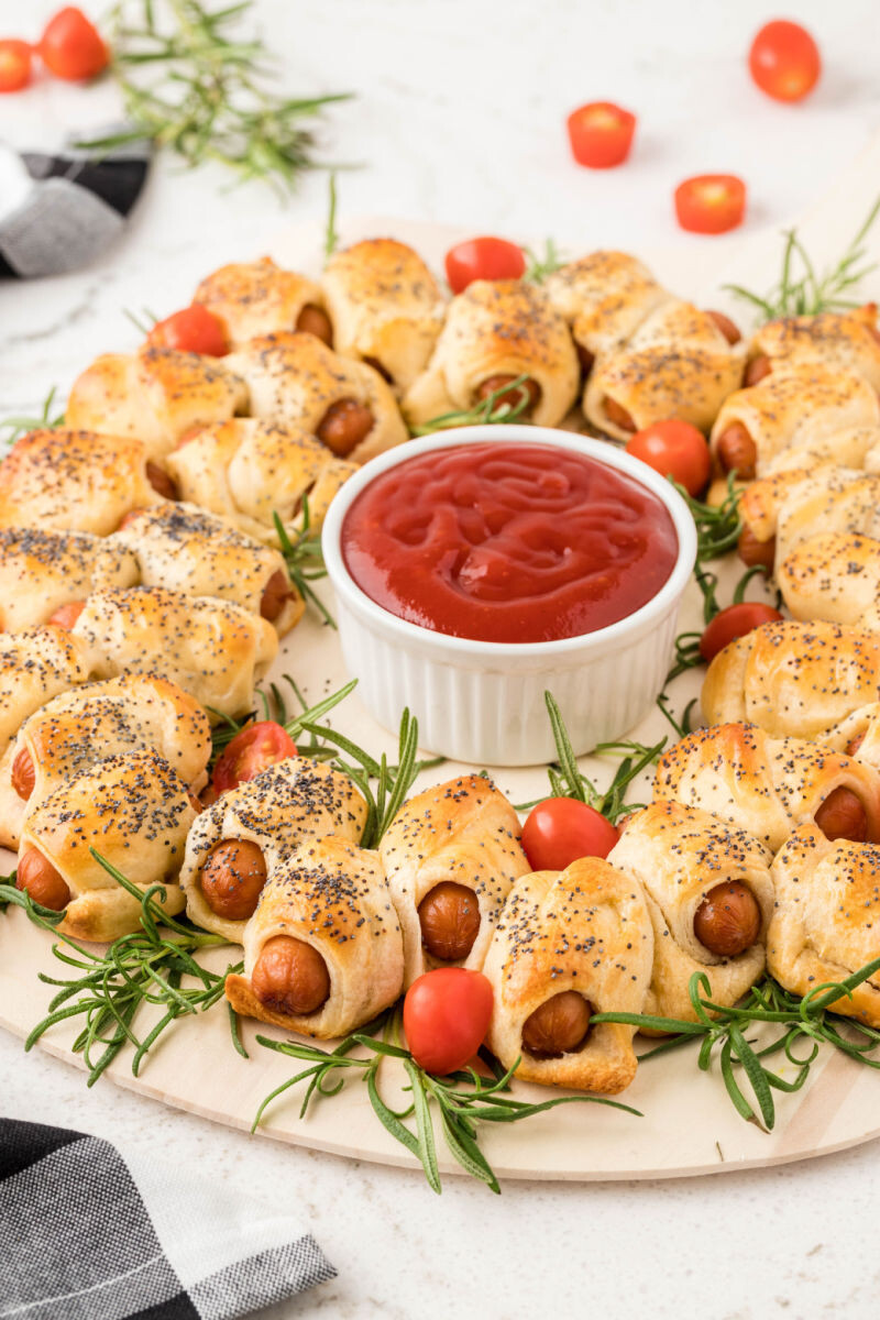 side view of pigs in a blanket wreath on a wooden board