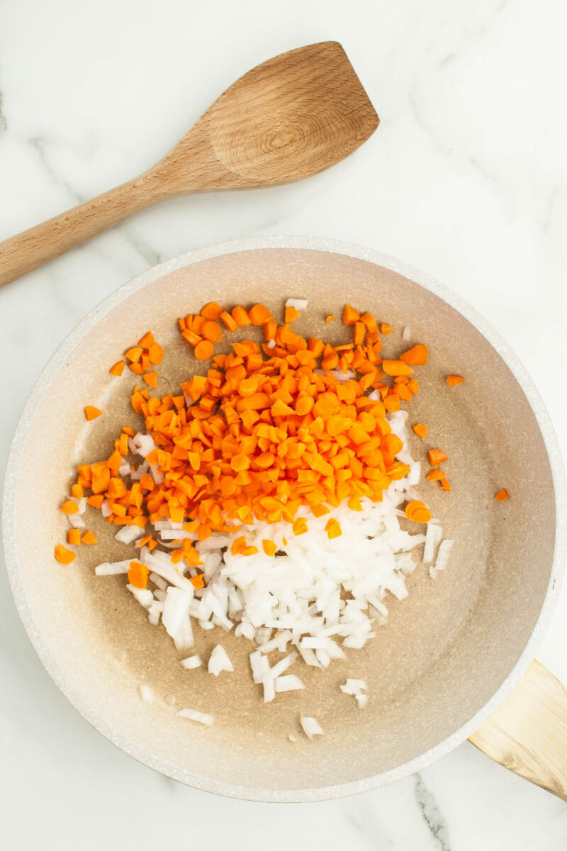 diced carrots and onions in a skillet