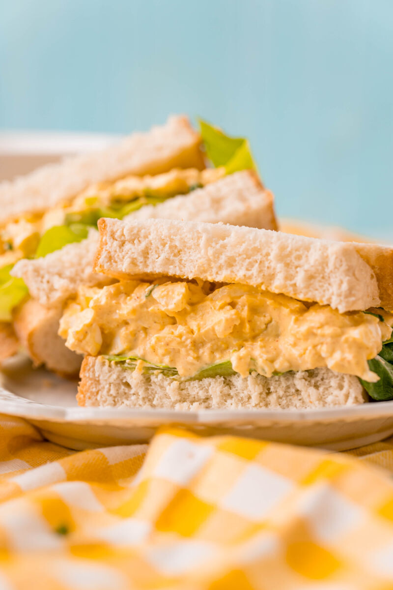 side view of an egg salad sandwich with lettuce on plate