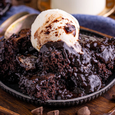 square image of chocolate pudding cake topped with vanilla ice cream