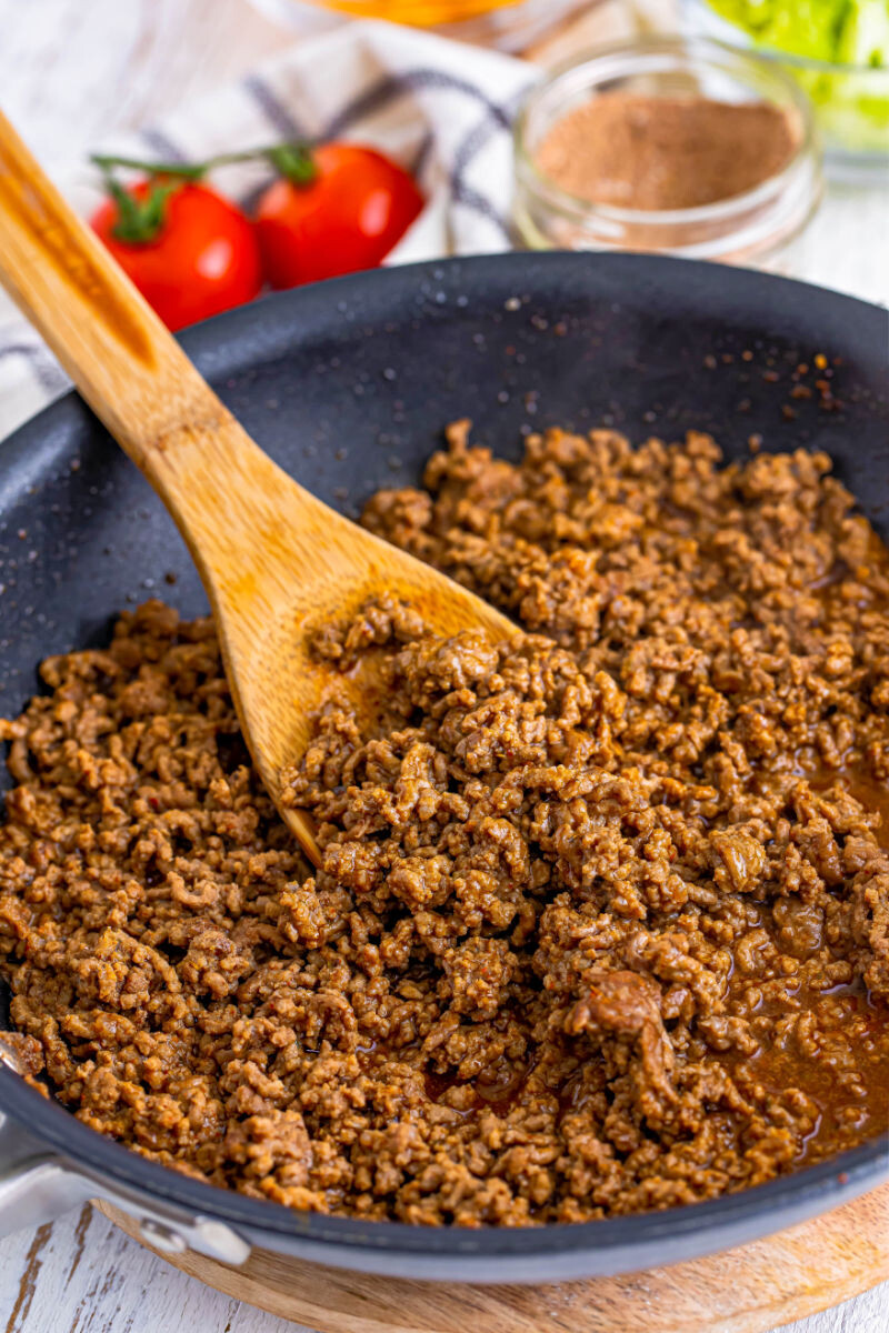 taco meat for ground beef tacos in a skillet with a wooden spoon