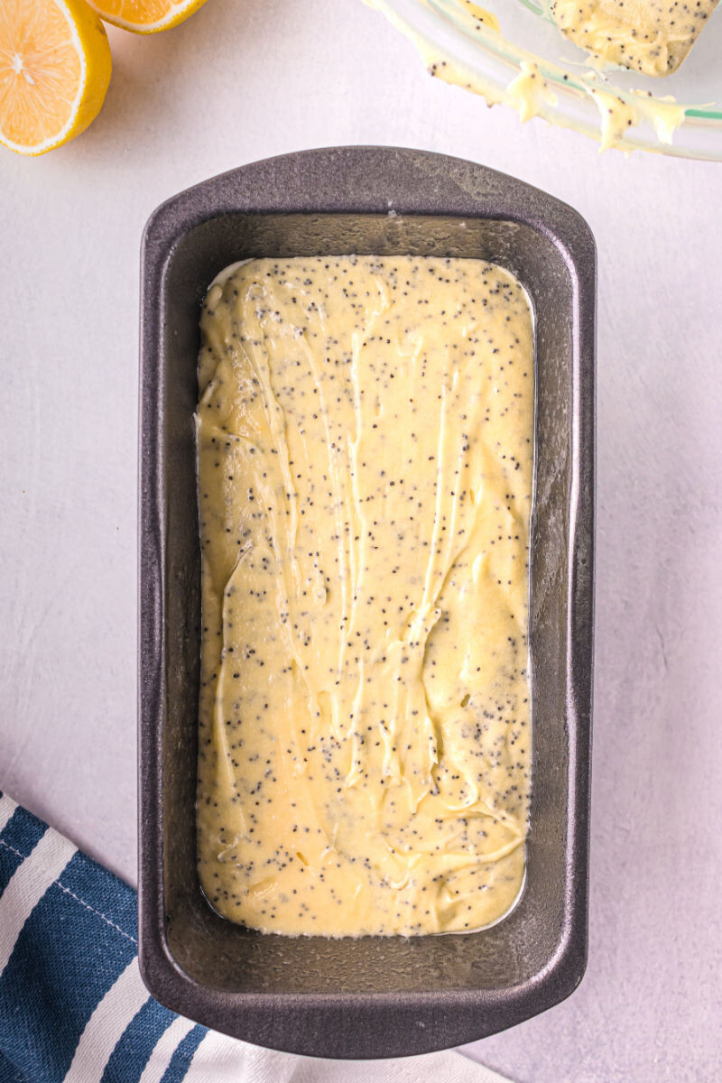 poppy seed almond pound cake batter in a greased loaf pan