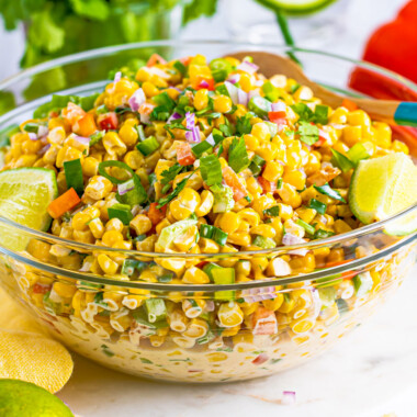 square image of tex-mex corn salad in a glass serving bowl