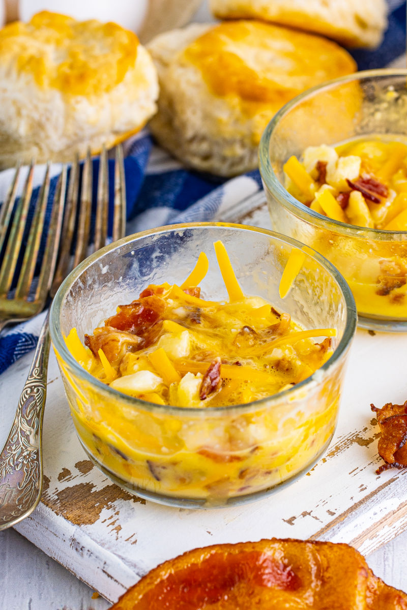 an egg mixed into the potato, bacon, and cheese in a glass bowl