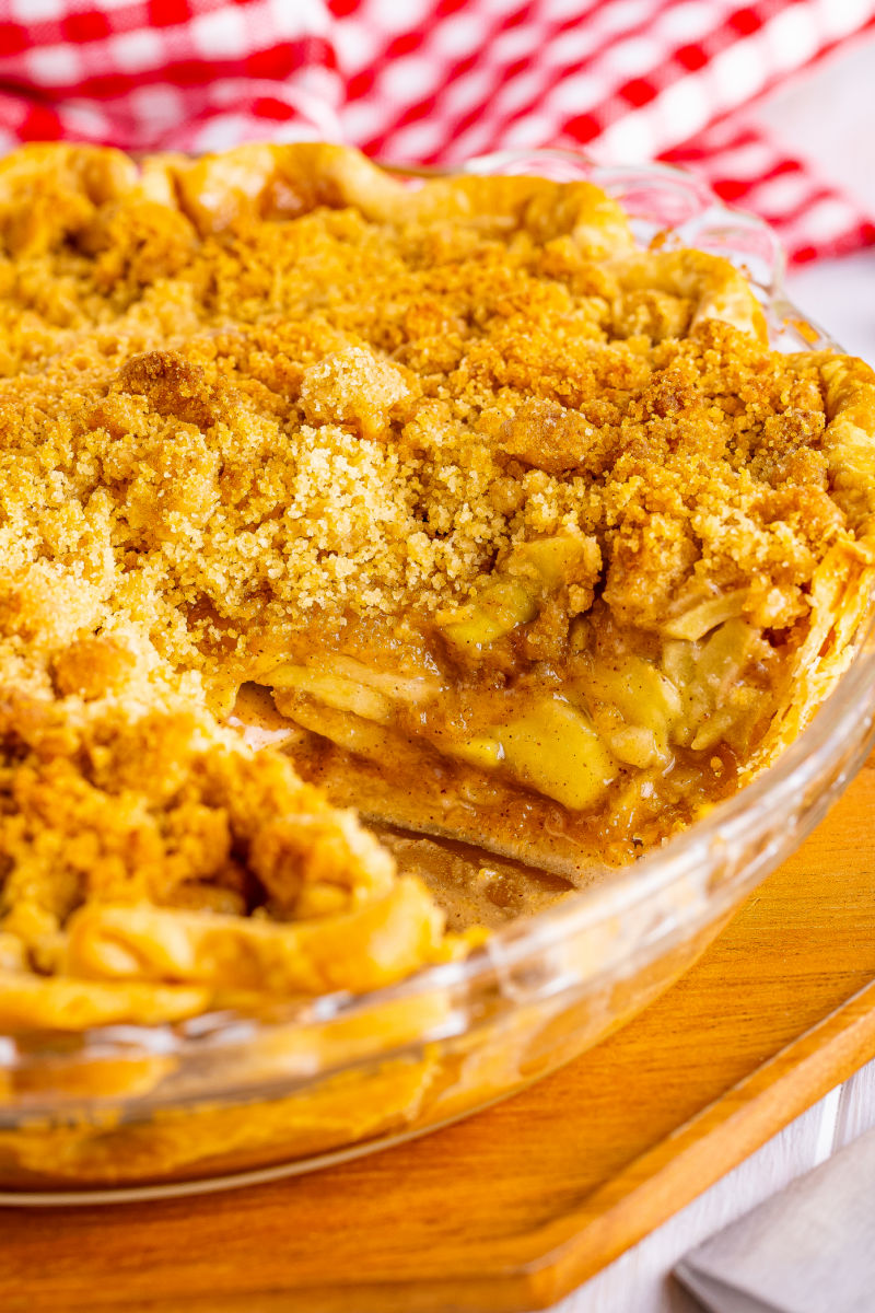 close up of an Apple Crumb Pie with a slice taken out to show the layers of apple inside