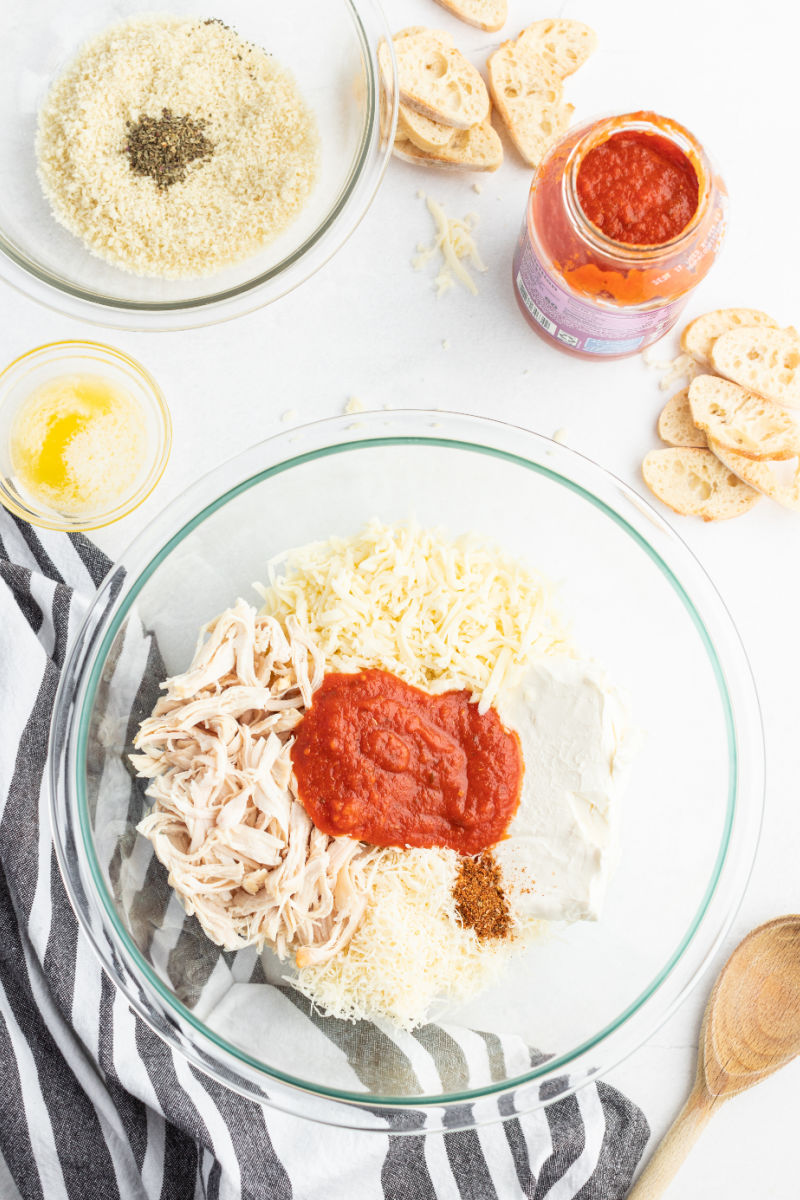 cream cheese, mozzarella, parmesan, shredded chicken, pasta sauce, and seasonings in a mixing bowl