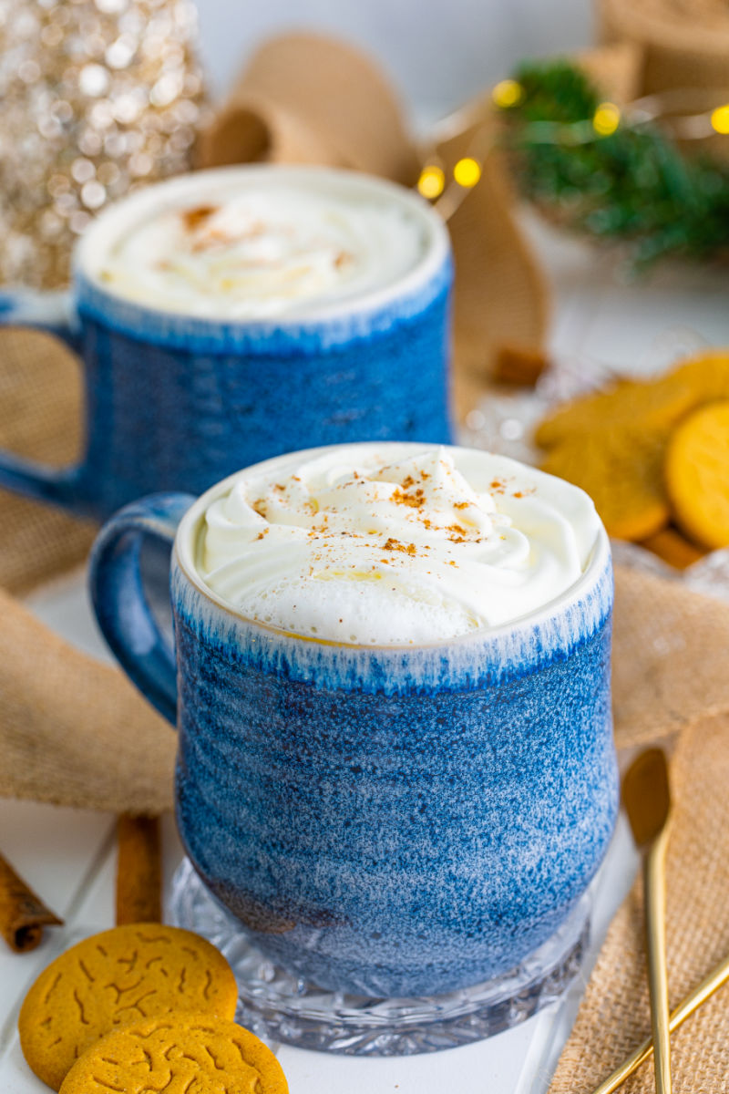 copycat starbucks gingerbread latte in a mug with whipped cream and ground cinnamon on top